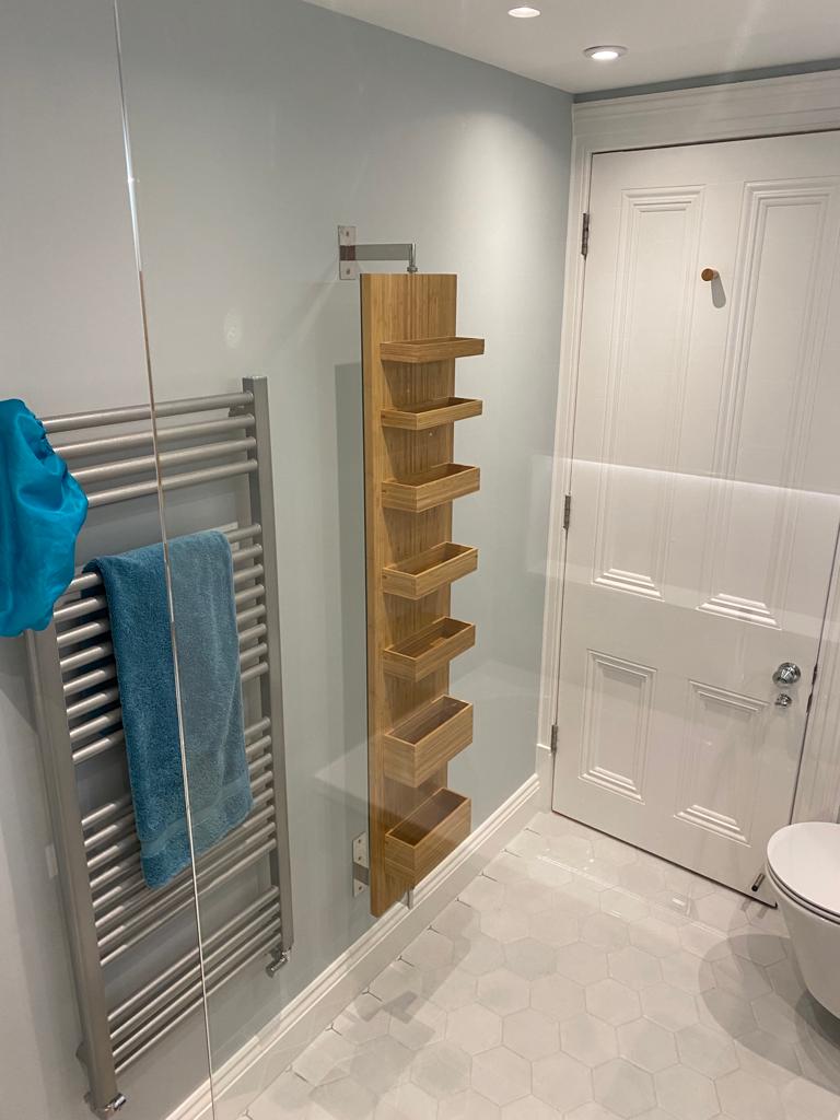 Heated towel rail and sleek, wooden shelving